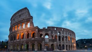 The Roman Colosseum basking in bright morning sunlight under a clear blue sky