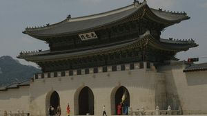 Gwanghwamun Gate with traditional curved eaves and mountains in the background in Seoul